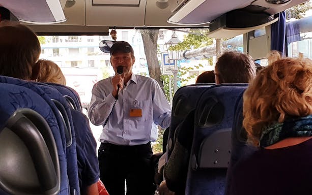 Tour guide speaking to passengers on a bus during a half-day tour from Dresden to Meissen and Moritzburg Castle.