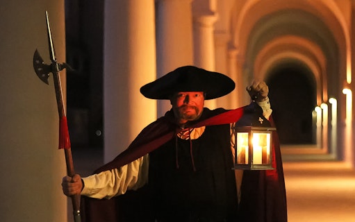 Night watchman holding lantern during guided tour in Dresden.