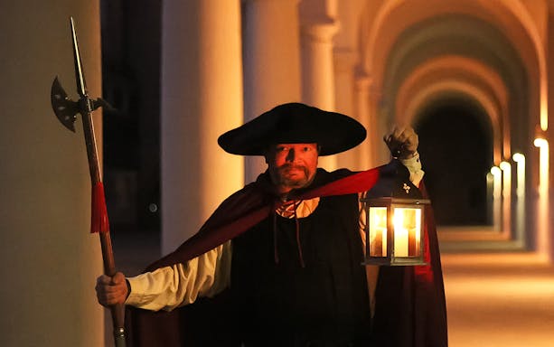 Night watchman holding lantern during guided tour in Dresden.