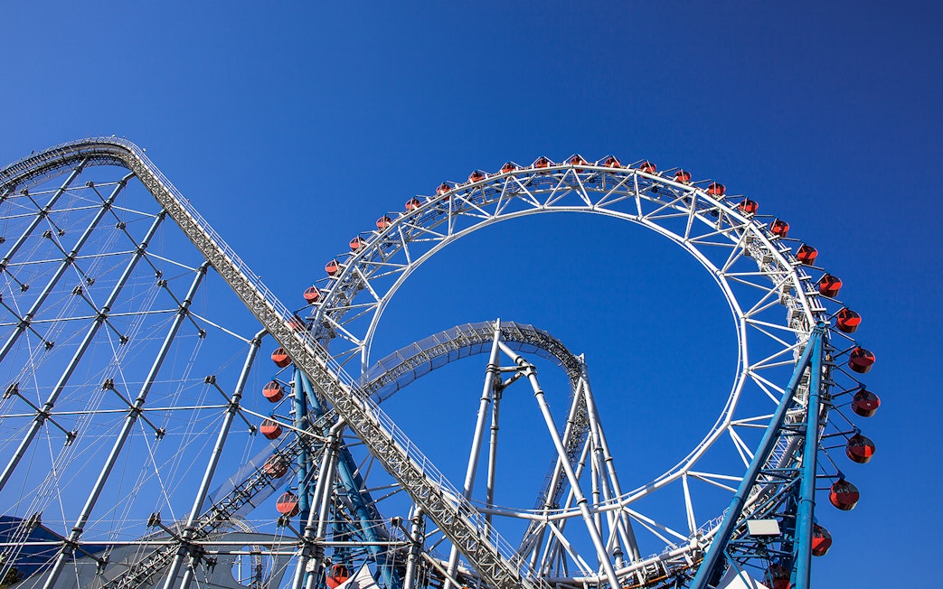 Roller coaster at Tokyo Dome City Attractions against blue sky.