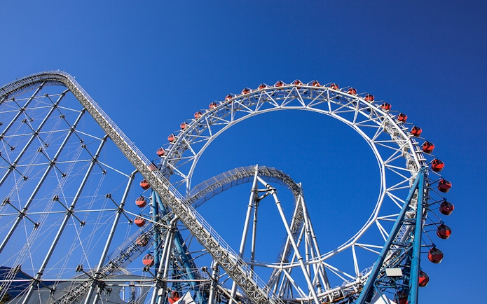 Roller coaster at Tokyo Dome City Attractions against blue sky.