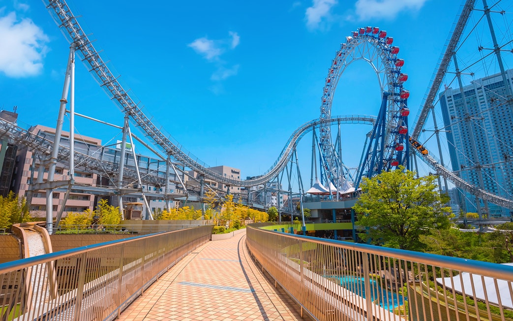 Roller coaster at Tokyo Dome City Attractions with cityscape background.