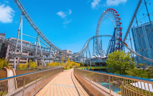 Roller coaster at Tokyo Dome City Attractions with cityscape background.