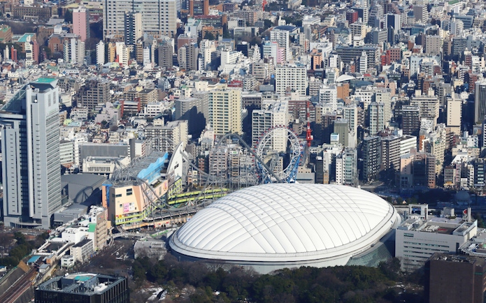 Tokyo Dome City with amusement park rides and surrounding cityscape.