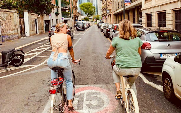 Cyclists exploring a street in Milan on the Hidden Treasures Bike Tour.