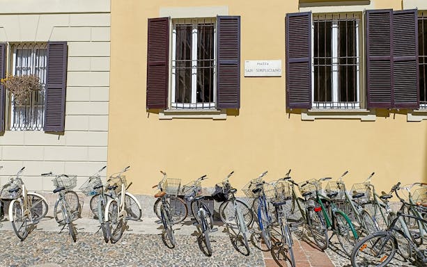 Bicycles lined up in front of a building at Piazza San Simpliciano, Milan.