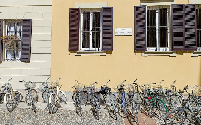 Bicycles lined up in front of a building at Piazza San Simpliciano, Milan.