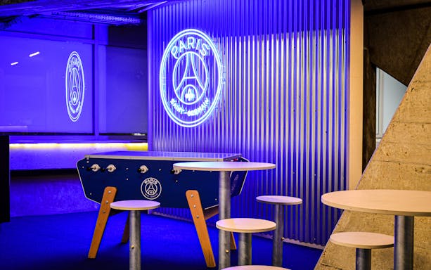 Paris Saint-Germain lounge area with neon logo at Parc des Princes Stadium.