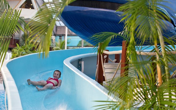 Child enjoying a water slide at Aquaboulevard, Paris.