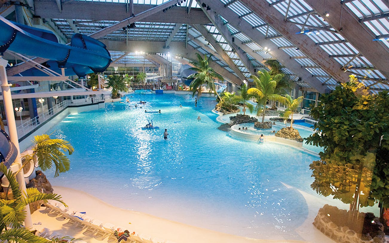 Indoor water park with wave pool and slides at Aquaboulevard, Paris.