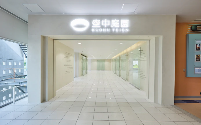 Umeda Sky Building interior hallway with glass walls and tiled floor, Osaka.