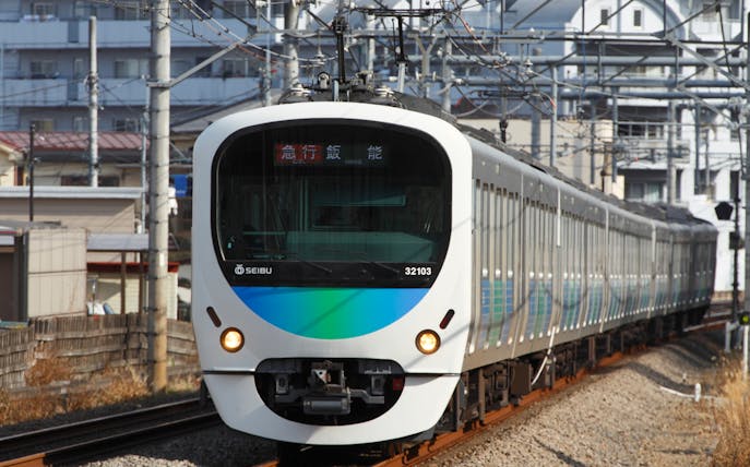 Seibu train traveling on tracks in urban Japan.