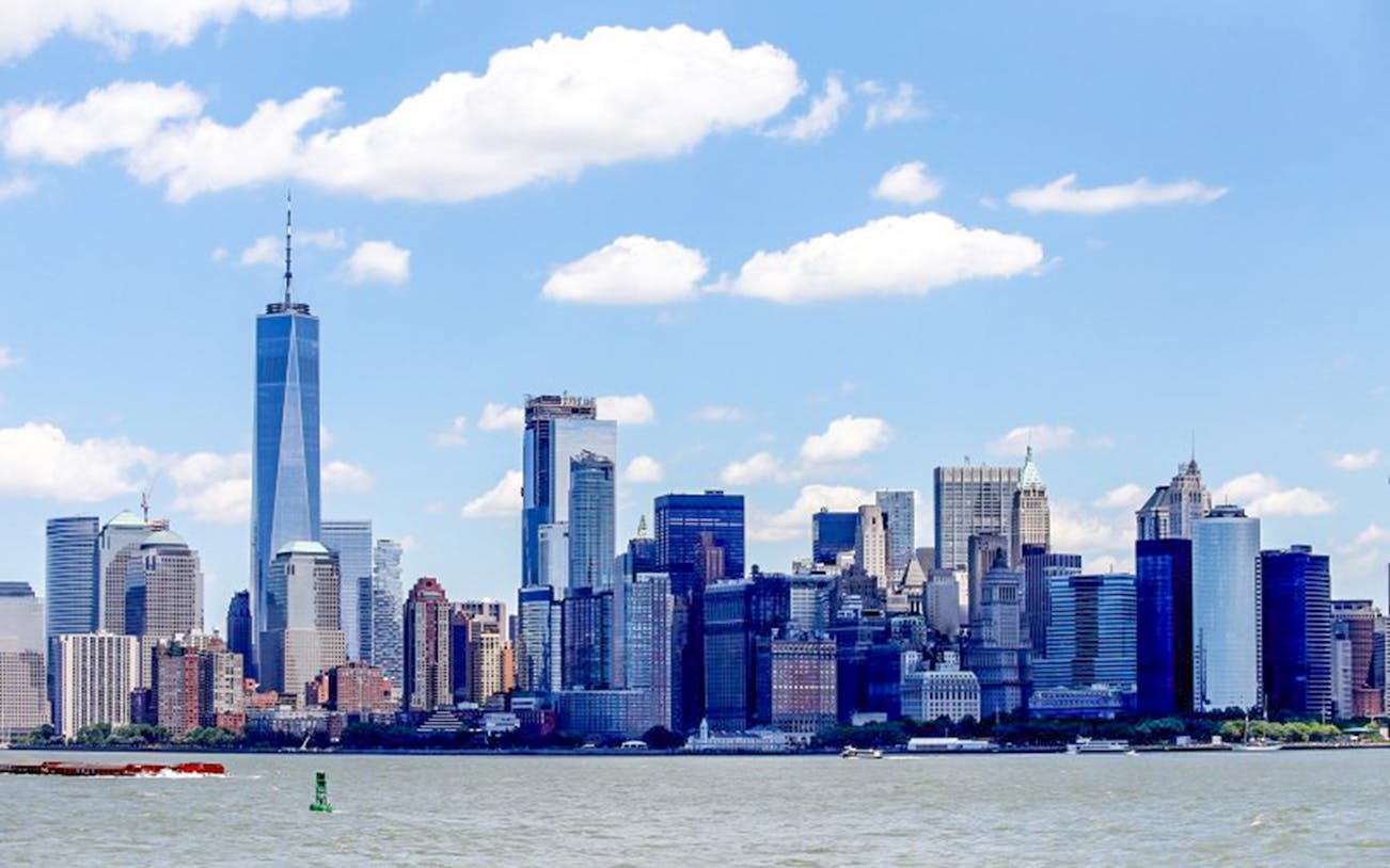 New York City skyline view from the water, featuring One World Trade Center.