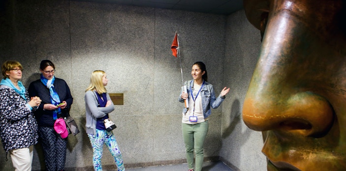 Guide explaining to tour group inside Statue of Liberty museum, New York.