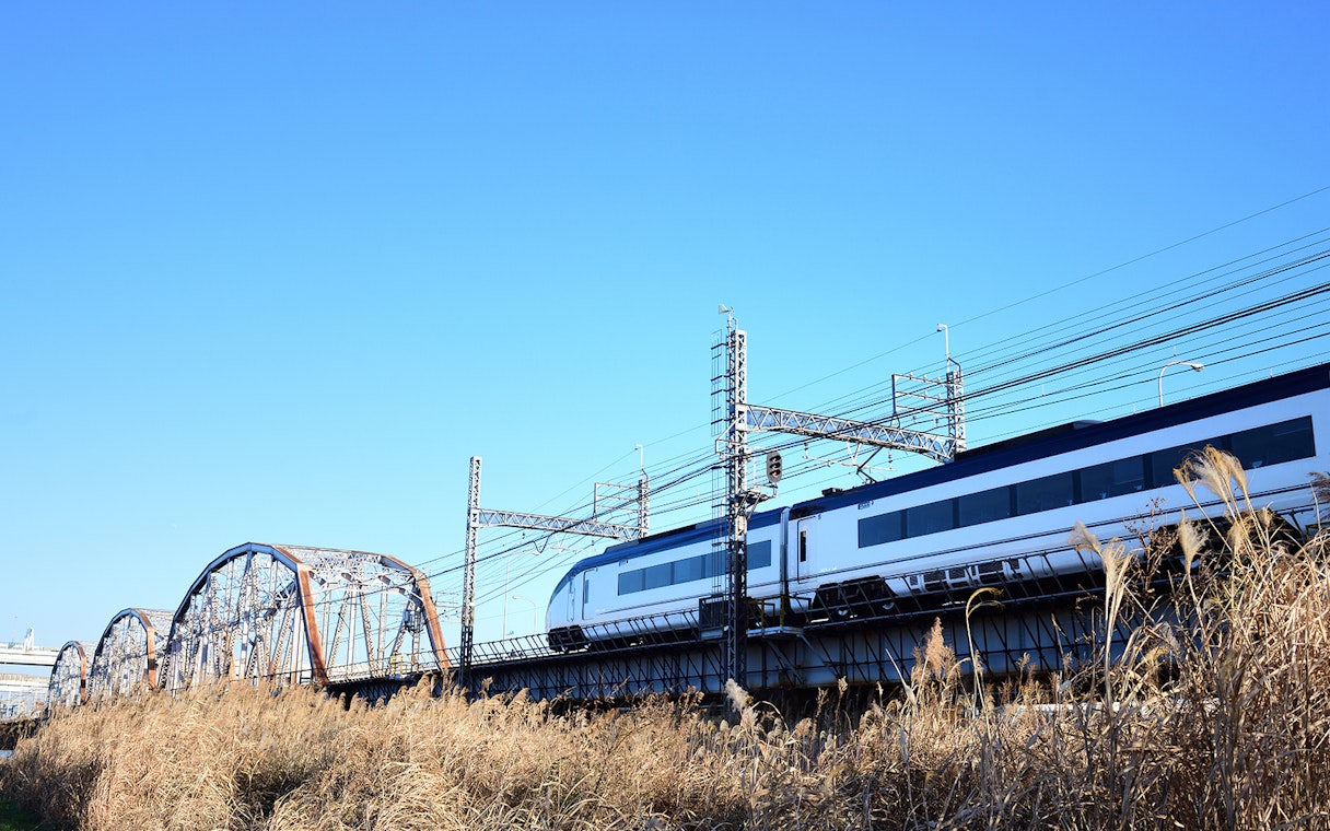 Tokyo Skyliner train crossing a bridge under a clear blue sky.