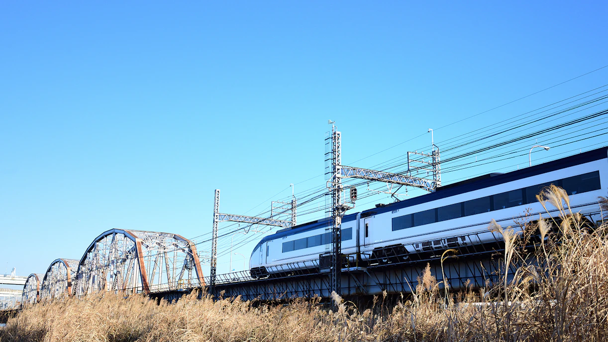 Tokyo Skyliner train crossing a bridge under a clear blue sky.
