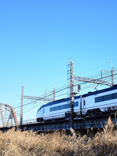 Tokyo Skyliner train crossing a bridge under a clear blue sky.