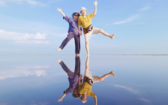 Couple enjoying Sky Mirror Experience in Kuala Selangor with clear reflections.