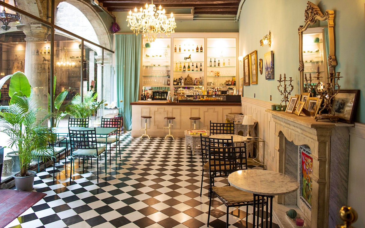 Palau Dalmases bar area with checkered floor and elegant decor, Barcelona.