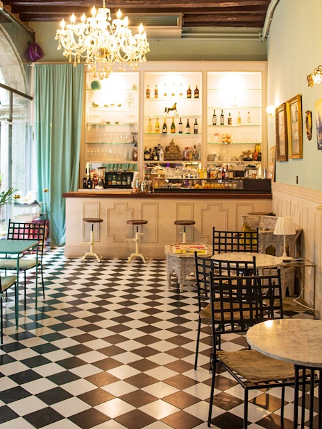 Palau Dalmases bar area with checkered floor and elegant decor, Barcelona.