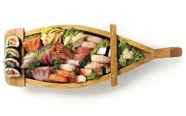 Sushi platter on a wooden boat, featuring assorted sashimi and rolls, for Riveria Romagnola Boat Tour.