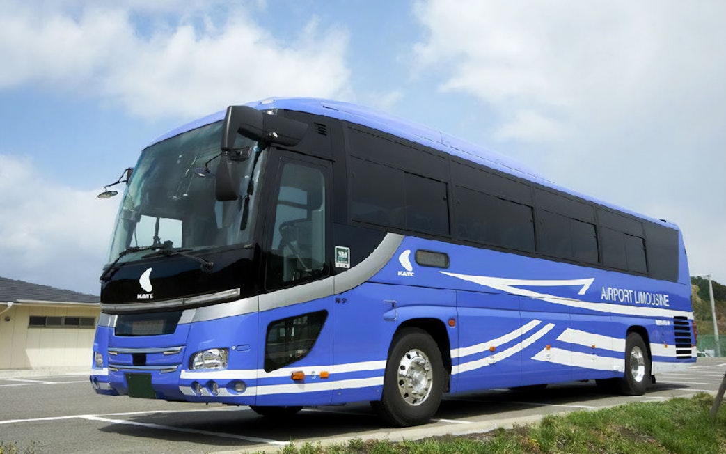 Kansai Airport Limousine Bus parked in a lot under a cloudy sky.