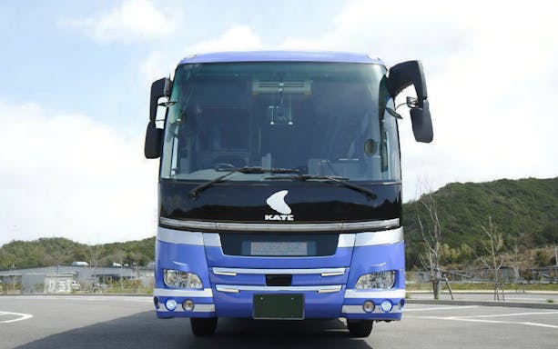 Kansai Airport bus parked in a lot with a scenic background.