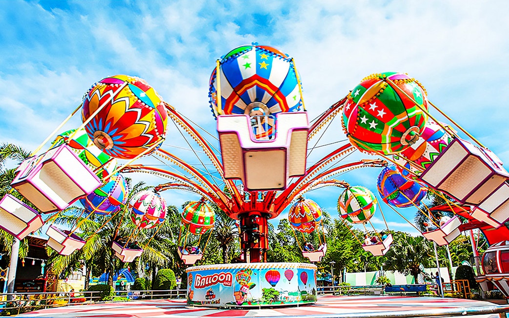 Colorful balloon ride at Siam Amazing Park, Bangkok, surrounded by palm trees.
