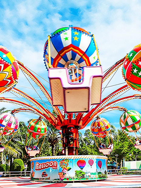 Colorful balloon ride at Siam Amazing Park, Bangkok, surrounded by palm trees.