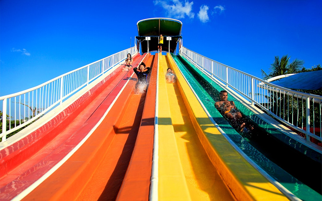 Visitors enjoying colorful water slides at Siam Amazing Park, Bangkok.