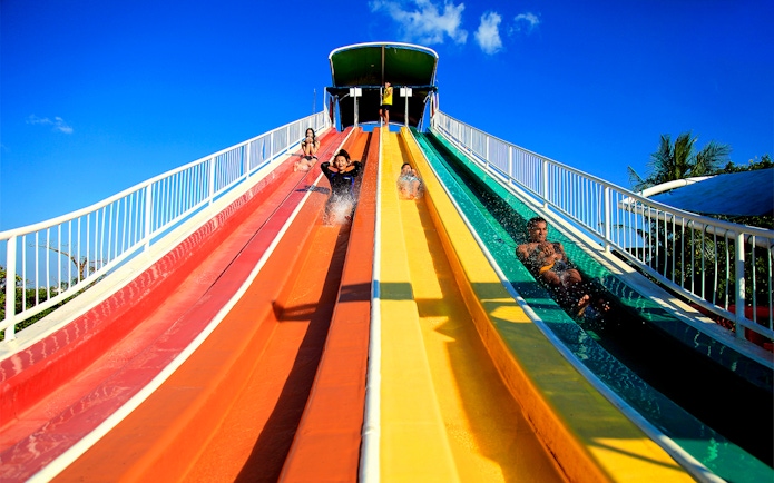 Visitors enjoying colorful water slides at Siam Amazing Park, Bangkok.