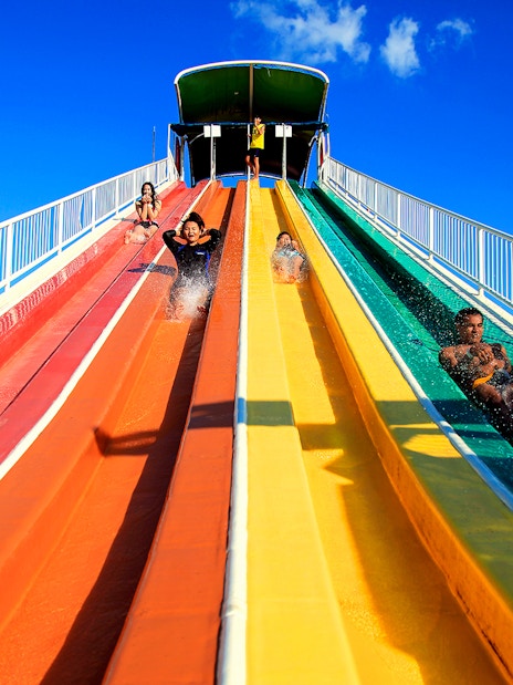 Visitors enjoying colorful water slides at Siam Amazing Park, Bangkok.