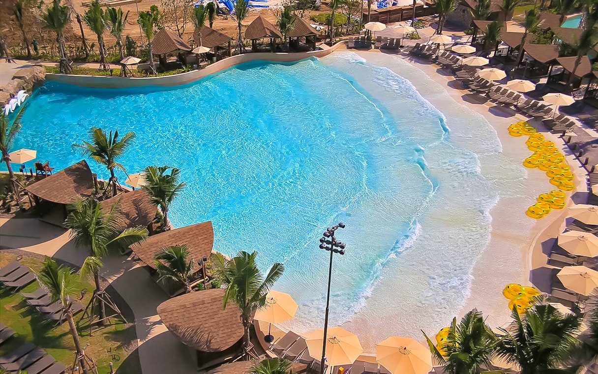 Wave pool at Vana Nava Water Jungle with surrounding cabanas and sun loungers.