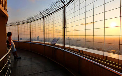 Baiyoke Sky Hotel observation deck view at sunset, Bangkok skyline in background.