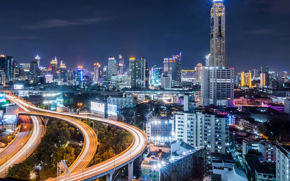 Bangkok skyline at night with Baiyoke Sky Hotel towering above city lights.