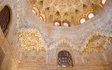 Alhambra's intricate stucco ceiling and arches on guided tour from Malaga.