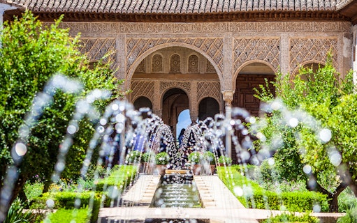 Alhambra's intricate arches and garden fountains on a guided tour from Seville.