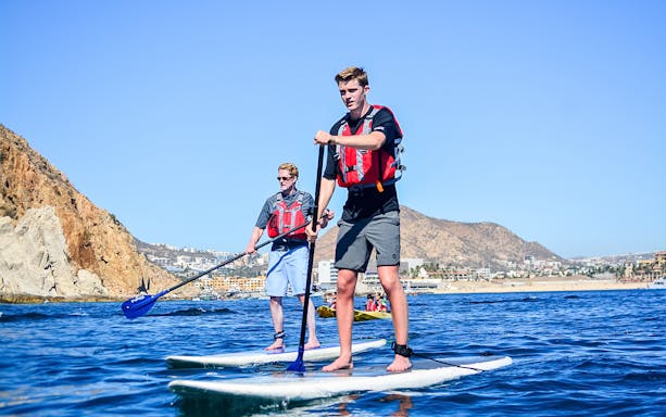 Paddleboarding near rocky cliffs in Cabo San Lucas.