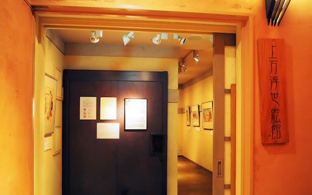Entrance to Kamigata Ukiyoe Museum with framed artworks on walls, Osaka, Japan.