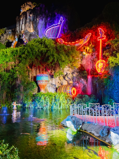 Phuket Fantasea neon-lit sculptures and water feature at night.