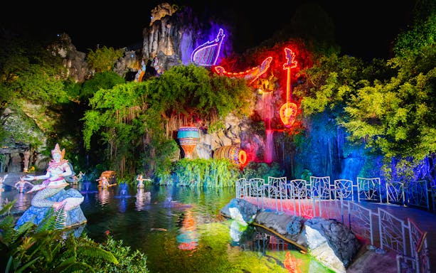 Phuket Fantasea neon-lit sculptures and water feature at night.