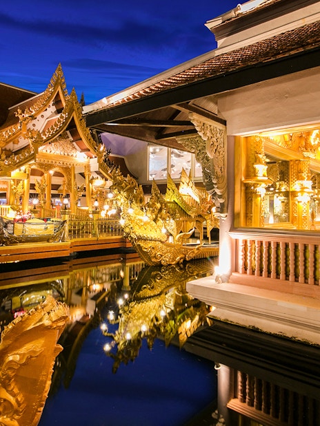 Golden Kinnaree Buffet Restaurant at Phuket Fantasea, featuring ornate golden architecture and reflections in water.