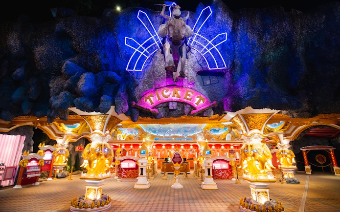 Phuket Fantasea entrance with neon lights and ticket booths.