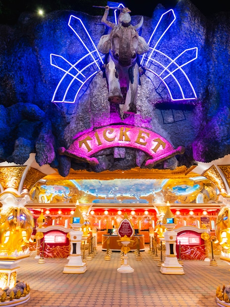 Phuket Fantasea entrance with neon lights and ticket booths.