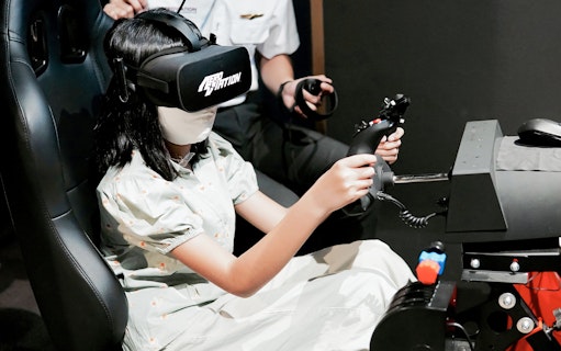 Person using a flight simulator with VR headset at Aeroviation Full Flight Experience.