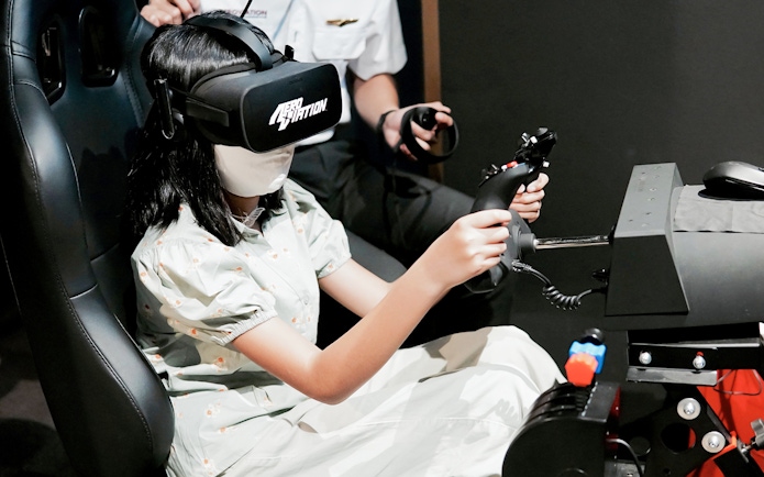 Person using a flight simulator with VR headset at Aeroviation Full Flight Experience.