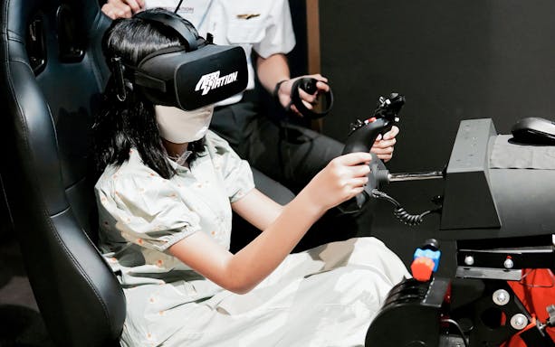 Person using a flight simulator with VR headset at Aeroviation Full Flight Experience.