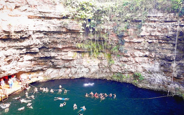 Tourists swimming in a cenote near Chichén Itzá, with a Mexican buffet-style lunch from Mérida.