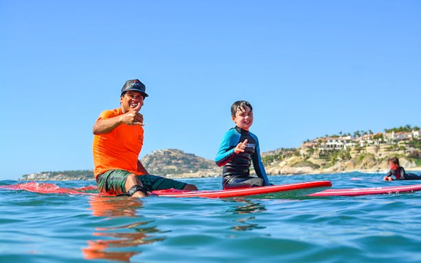 Surf instructor and student giving thumbs up during a lesson at Costa Azul, Los Cabos.