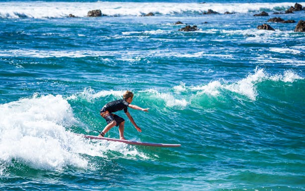 Surfer riding a wave during a private lesson at Costa Azul, Los Cabos.